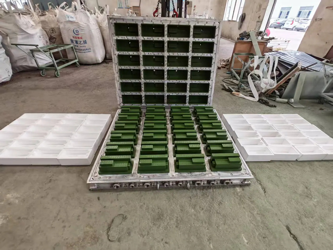 Open EPS mold with matching foam parts laid beside the cavity plate